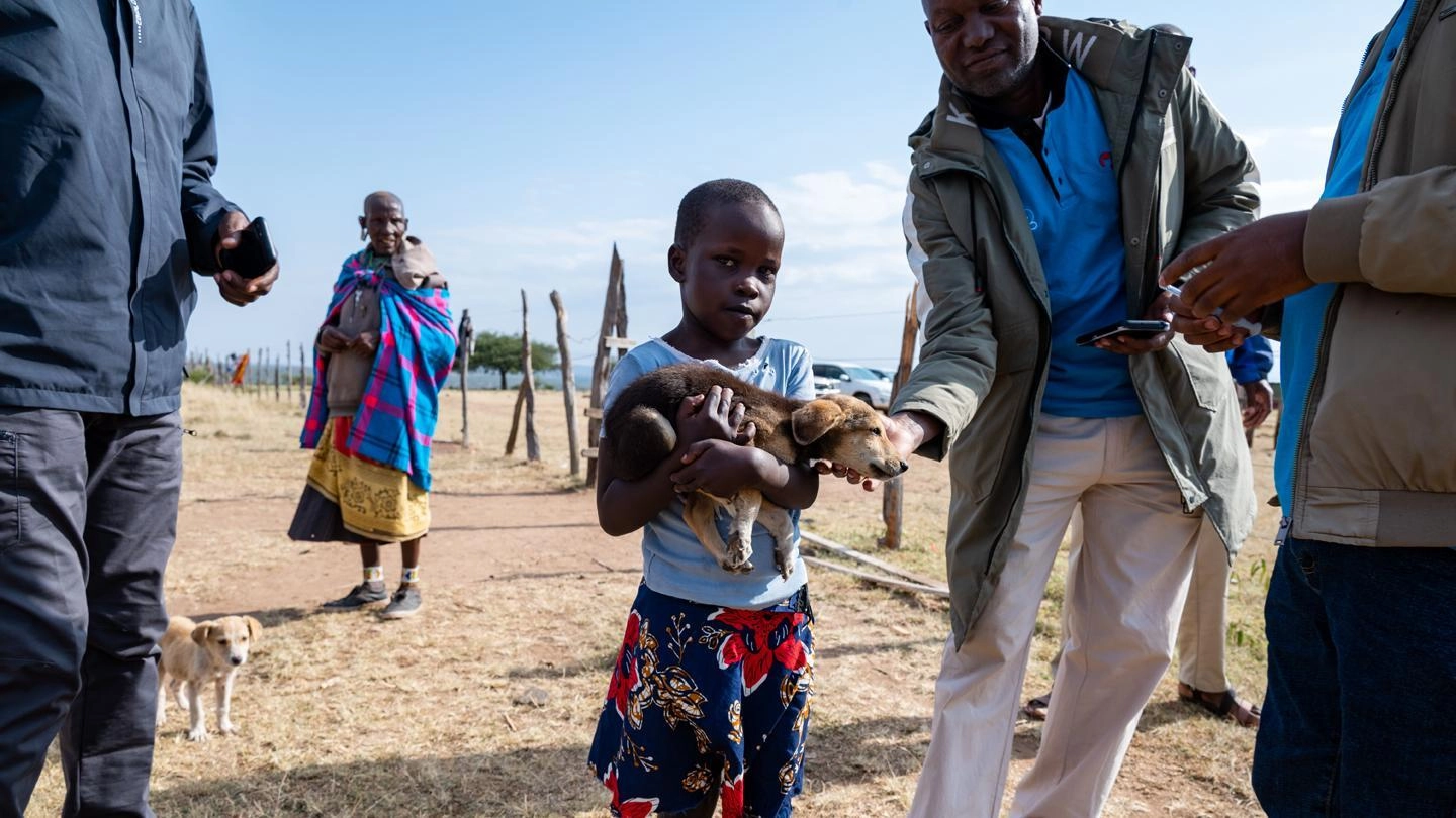 Kid holding puppy in Kenya