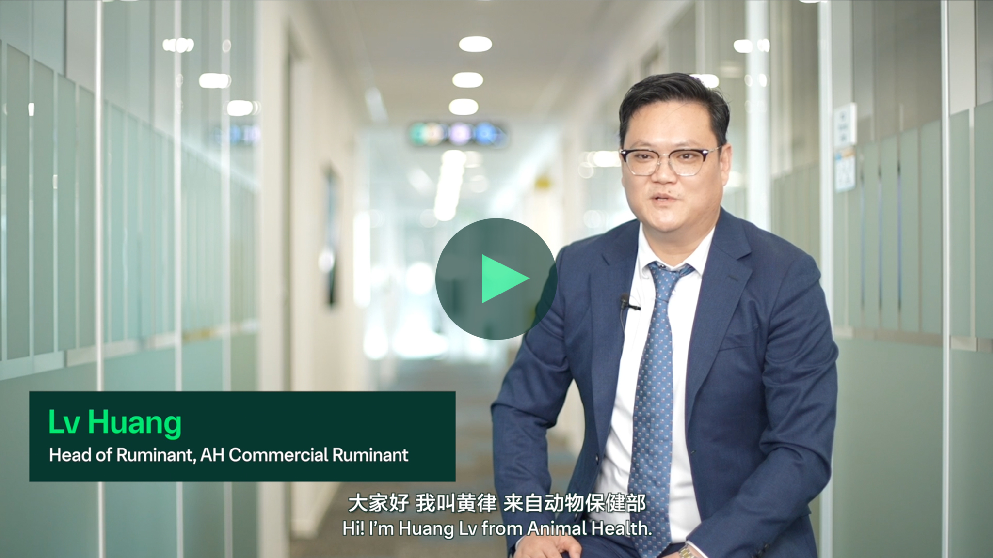 室内拍摄，一位人物坐着接受采访，背景有彩色圆形图案，画面中有播放按钮。